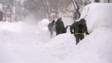 People shovelling mounds of snow in Cambridge, Massachusetts
